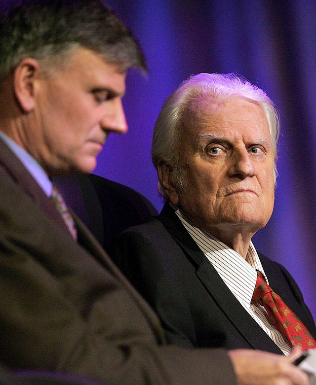 In this March 12, 2006 photo, the Rev. Billy Graham (right) and his son Franklin Graham wait for the start of a service in New Orleans. (AP Photo/Bill Haber, File)