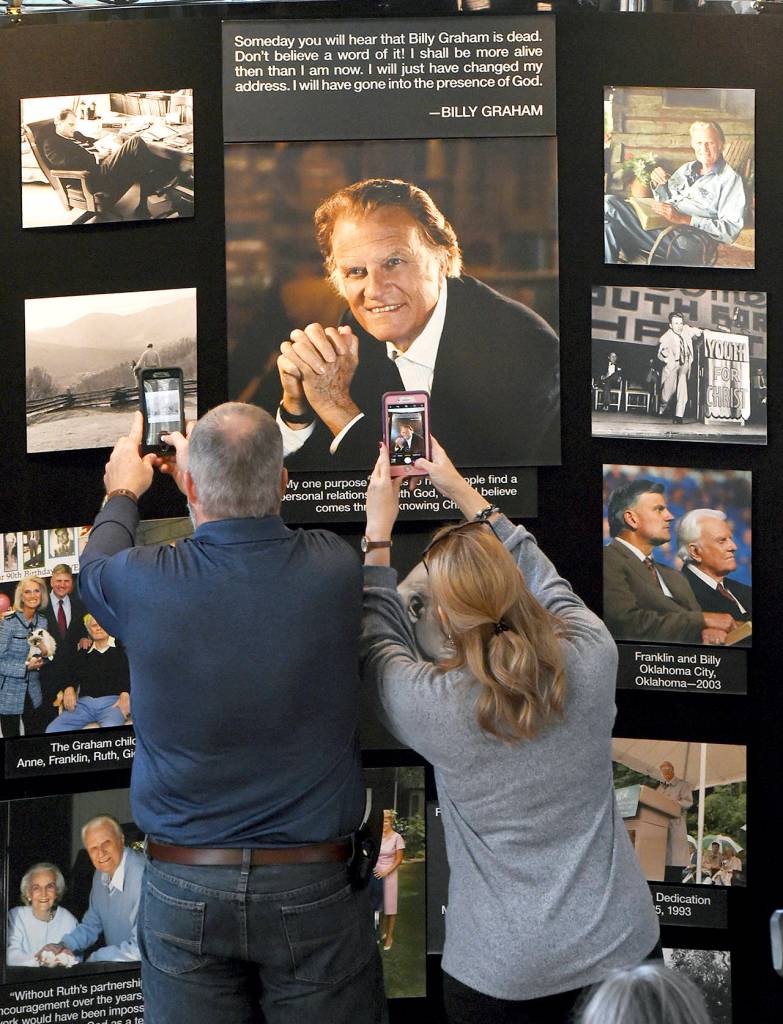 Chuck and Angela Riddle, of Morganton, North Carolina, photograph a memorial display in tribute to Rev. Billy Graham inside the chapel at the Billy Graham Training Center at the Cove on Wednesday in Asheville, North Carolina. The couple came to pay their respects and said Graham was a big influence in their lives. (AP Photo/Kathy Kmonicek)
