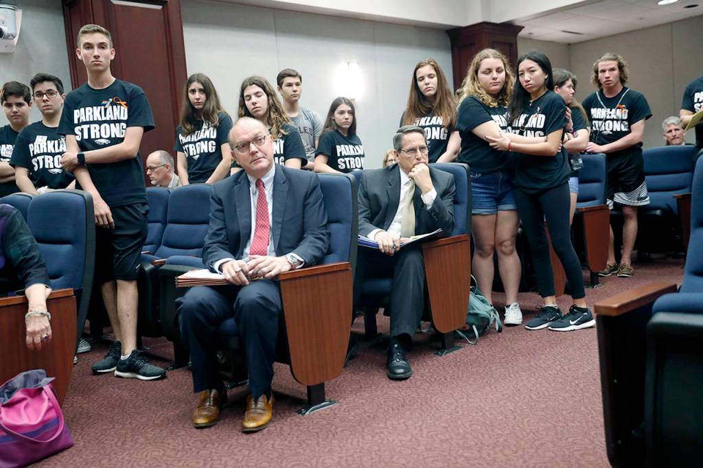 Lobbyists and attorneys listen as student survivors from Marjory Stoneman Douglas High School interrupt a house legislative committee hearing to challenge lawmakers on gun control reform in Tallahassee on Wednesday. (AP Photo/Gerald Herbert)