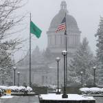 Snow falls and sticks to tree branches on Tuesday at the Capitol in Olympia. (Ted S. Warren / Associated Press)