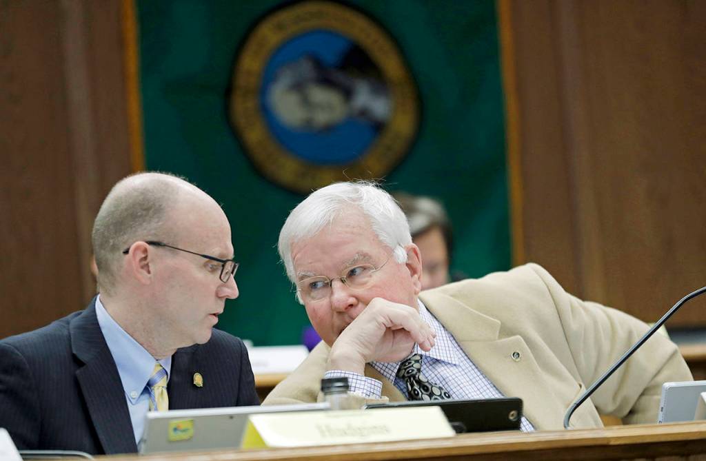 Sen. Sam Hunt (right), D-Olympia, the chairman of the State Government, Tribal Relations and Elections Committee, confers with Rep. Zack Hudgins (left), D-Tukwila, chairman of the State Government, Elections & Information Technology Committee, during a joint work session Thursday at the Capitol in Olympia. (AP Photo/Ted S. Warren)