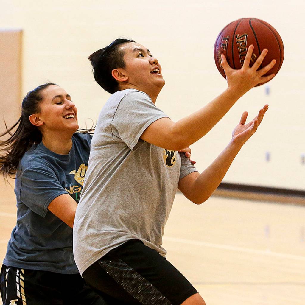 Lynnwoods Vang Vo (right) takes a shot during a practice at the school on Thursday, Feb. 22. (Ian Terry / The Herald)
