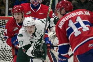 Spokanes Jeff Faith (left-right) Everetts Matt Fonteyne and Spokanes Jaret Anderson-Dolan eye the puck at Angel of the Winds Arena Sunday afternoon in Everett on February 25, 2018. (Kevin Clark / The Daily Herald)