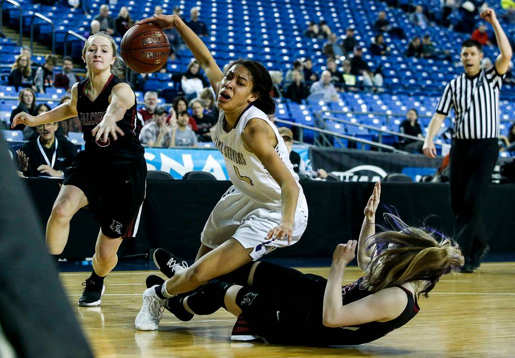 Lake Stevens Kylee Griffen (center) falls as shes guarded by Kentlakes Kiernen Denckla (right) during a girls 4A state tournament game at the Tacoma Dome on Wednesday, Feb. 28. Kentlake went on to defeat Lake Stevens 57-42. (Ian Terry / The Herald)