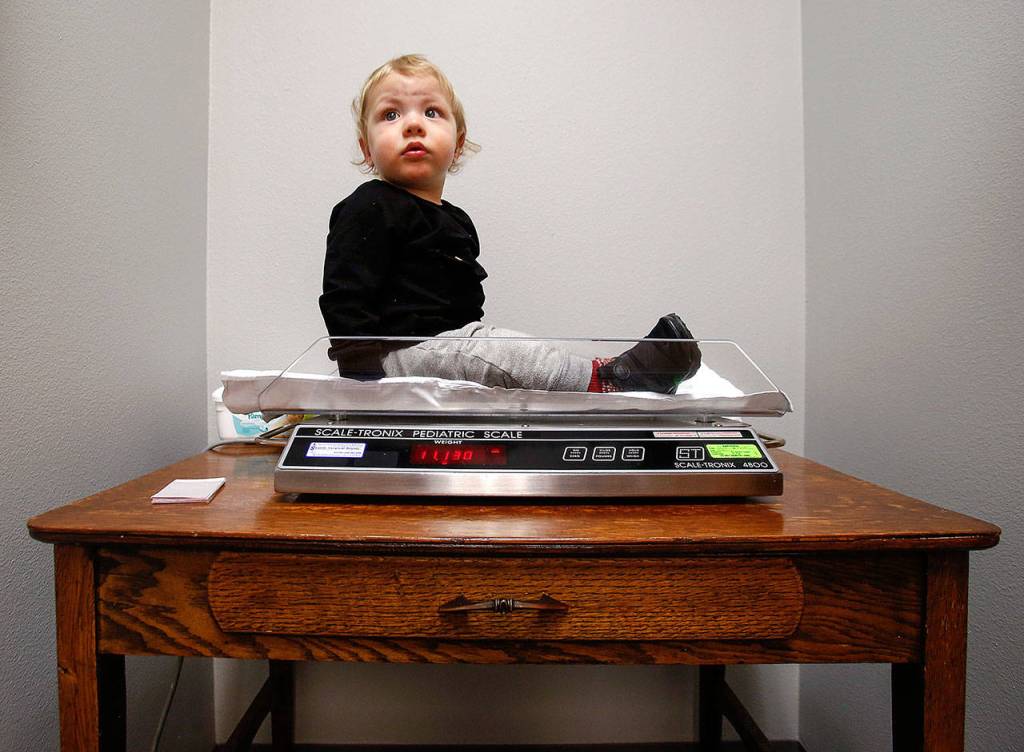 At Pacific Wellness and Lactation, Braylon Machado, 1, waits a moment for his mom and caregiver BreAnne Marcucci to check his weight on a pediatric scale. (Dan Bates / The Herald)