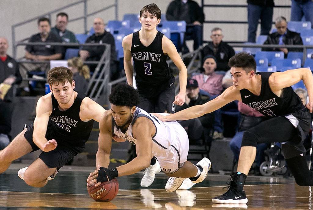 Unions Alishawuan Taylor (center) and Kamiaks Braden Leary dives for a loose ball with Kamiaks Patrick Olson (right) and Kamiaks Dakota Bueing (standing ) looking on during the WIAA state basketball tournament Wednesday at the Tacoma Dome in Tacoma on February 28, 2018. (Kevin Clark / The Daily Herald)