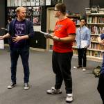 Kamiak High School drama teacher Bryan Sullivan (left) helps students Jack Burrows (center), Eddie Kouthong (center right) and Martin Albrecht (right) with lines during a Spamalot rehearsal on Thursday. (Ian Terry / The Herald)