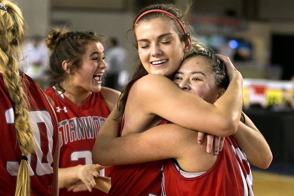 Stanwoods Ashley Alter (center), Kayla Frazier (right) and Madison Chisman (rear) celebate a win over Lincoln at the 3A girls Hardwood Classic on March 1, 2018, at the Tacoma Dome. The Spartans beat the top-seeded Abes 49-39 to advance to the state semifinals against Garfield. (Kevin Clark / The Herald)