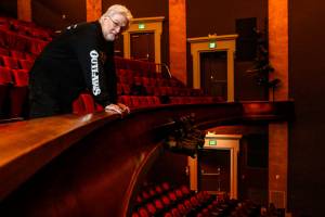 Curt Shriner looks out from behind the balcony rail in the Historic Everett Theatre, which he has operated since 2014. The 117-year-old theater, owned by his brother, Craig Shriner, is for sale with an asking price of $2,450,000. (Dan Bates / The Herald)