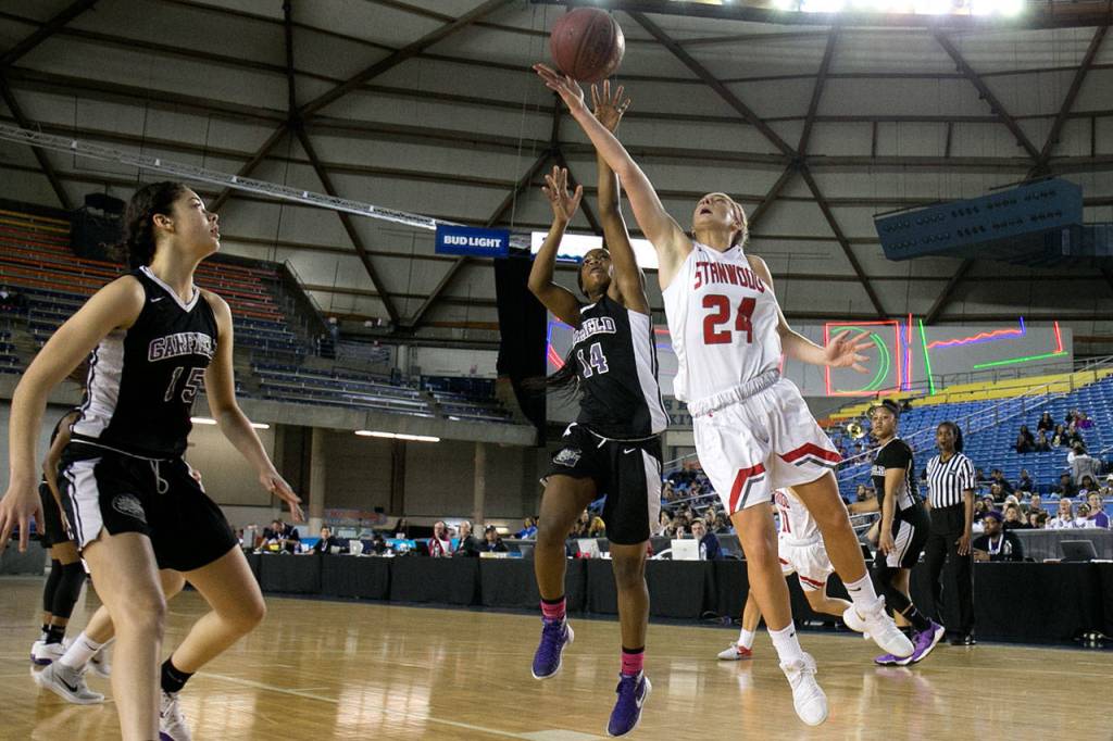 Stanwoods Jillian Heichel attempts a shot with Garfields Emani Turner defending and Garfields Dalayah Daniels (far left) looking on during the semifinals of the 3A Hardwood Classic on March 2, 2018, at the Tacoma Dome. (Kevin Clark / The Herald)