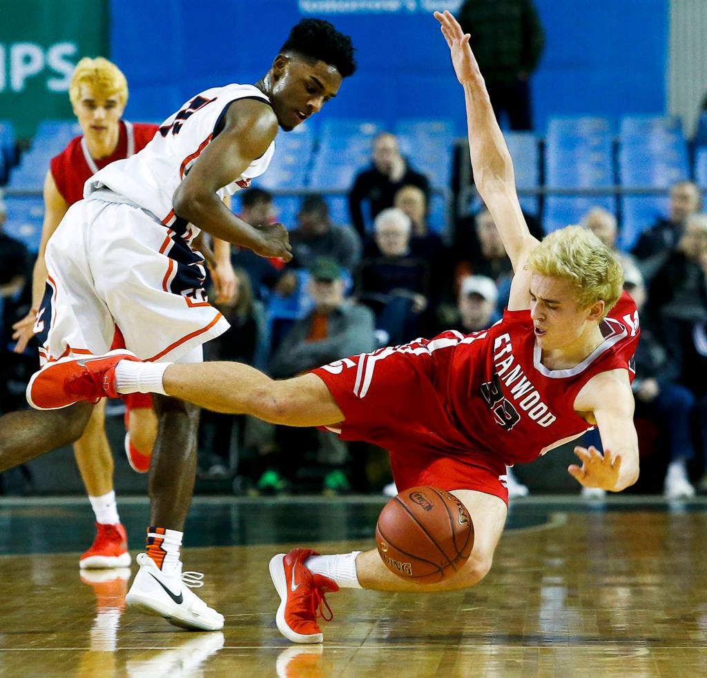Stanwoods Nate Kummer (right) is knocked down by Eastside Catholics Syon Blackmon (left) during a boys 3A state tournament game at the Tacoma Dome on Feb. 28. (Ian Terry / The Herald)