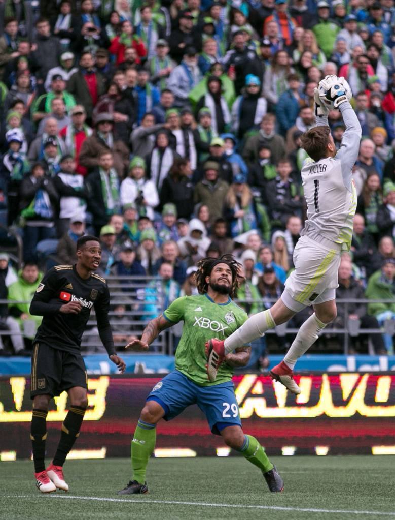 Los Angeles goalkeeper Tyler Miller gathers a shot with Sounders defender Romn Torres (center) and Los Angeles Mark_anthony Kaye (left) looking at CenturyLink Field on the Xbox Pitch Sunday afternoon in Seattle on March 4, 2018. Los Angeles FC won 1-0. (Kevin Clark / The Daily Herald)