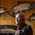 Wayne Kruse stands with fishing trophies at his home on Lake Cavanaugh on Tuesday, March 6, 2018, in Mount Vernon, Wa. Kruse, who has be writing outdoors stories for The Everett Herald since 1976, is retiring. Is this the best job in the world? he has been asked over the years. His answer, Yes, it is. (Andy Bronson / The Herald)