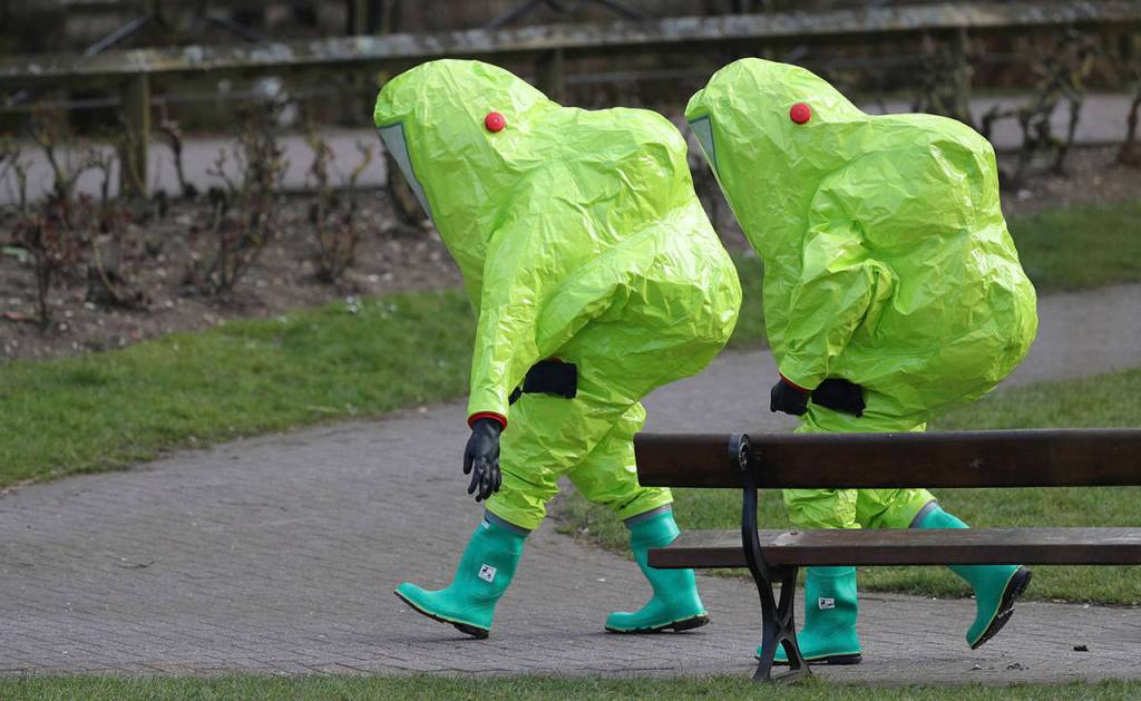 Personnel in hazmat suits walk away after securing the covering on a bench in the Maltings shopping centre in Salisbury, England on Thursday, where former Russian double agent Sergei Skripal and his daughter Yulia were found critically ill by exposure to a nerve agent on Sunday. (Andrew Matthews/PA via AP)