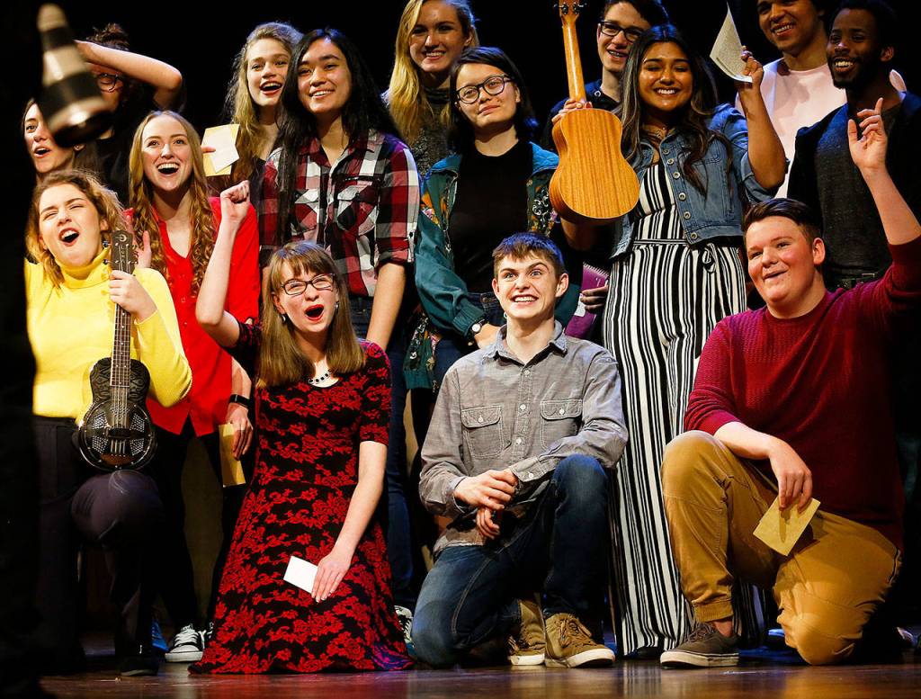 Marysville Pilchuck junior Laura Davis (bottom front in flowered dress) joins other high school students from the region back on the Paramount stage at the conclusion of student performances Wednesday. (Dan Bates / The Herald)