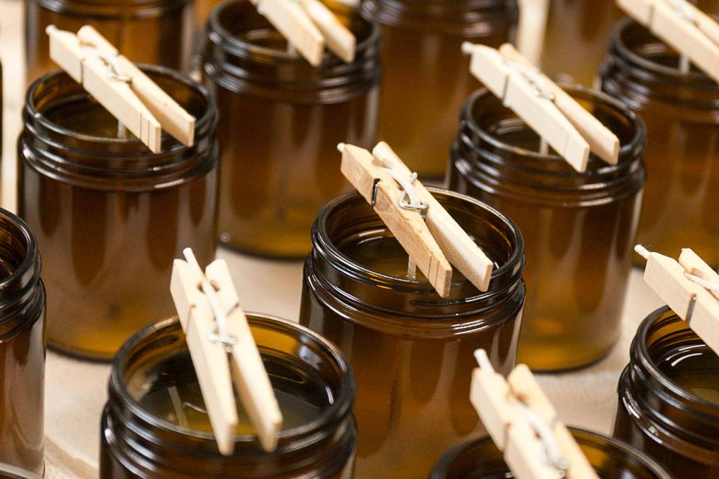 Clothespins hold the wicks in freshly pour candles in Lacie Marsh-Carrolls garage at her home in Lake Stevens. (Kevin Clark / The Herald)
