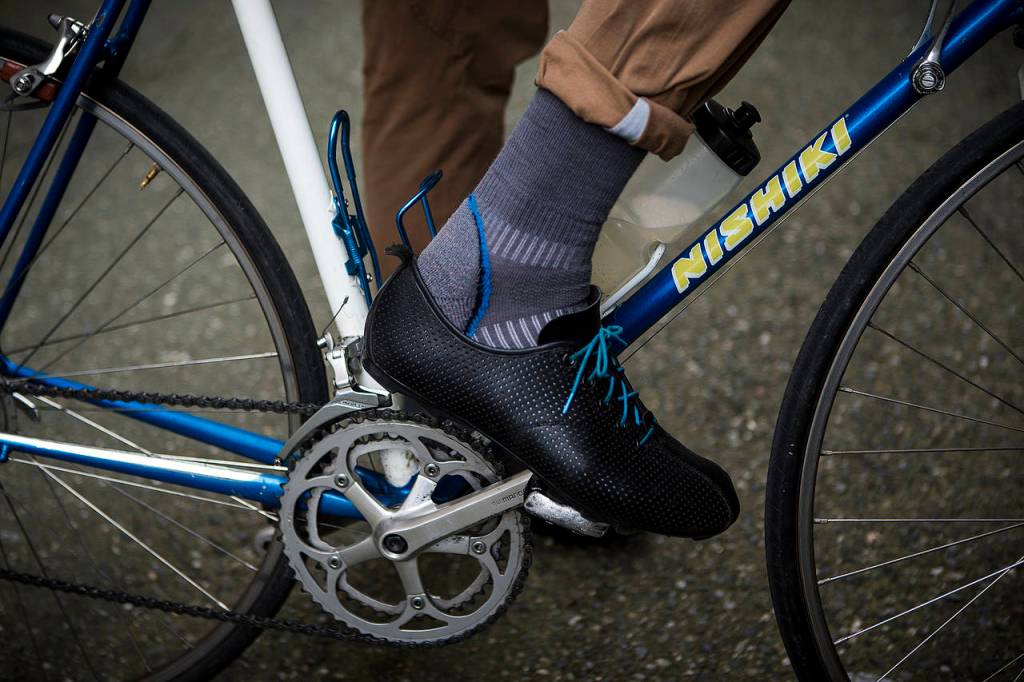 Warland Hewitt Wight wears leather cycling shoes he made by hand while working in downtown Everett on Tuesday. Wight designs his own clothing and footwear which are meant to look casual but still offer breathability and performance when cycling. (Ian Terry / The Herald)