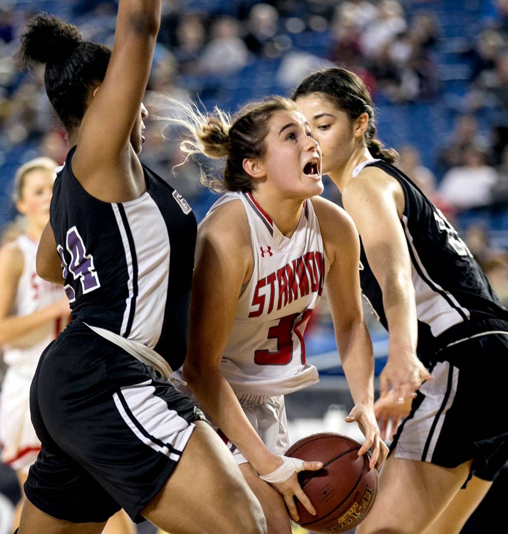Stanwoods Madison Chisman attempts a shot between Garfields Tamia Mobley (left) and Garfields Dalayah Daniels (right) during the semifinals of the 3A Hardwood Classic at the Tacoma Dome on March 2. (Kevin Clark / The Herald)