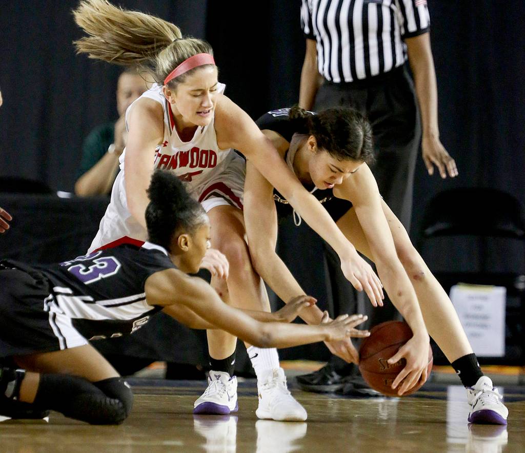 Stanwoods Jillian Heichel (center) vies for a loose ball against Garfields Samaiyah Tolliver (left) and Garfields Dalayah Daniels (right) during the semifinals of the 3A Hardwood Classic at the Tacoma Dome on March 2. (Kevin Clark / The Herald)