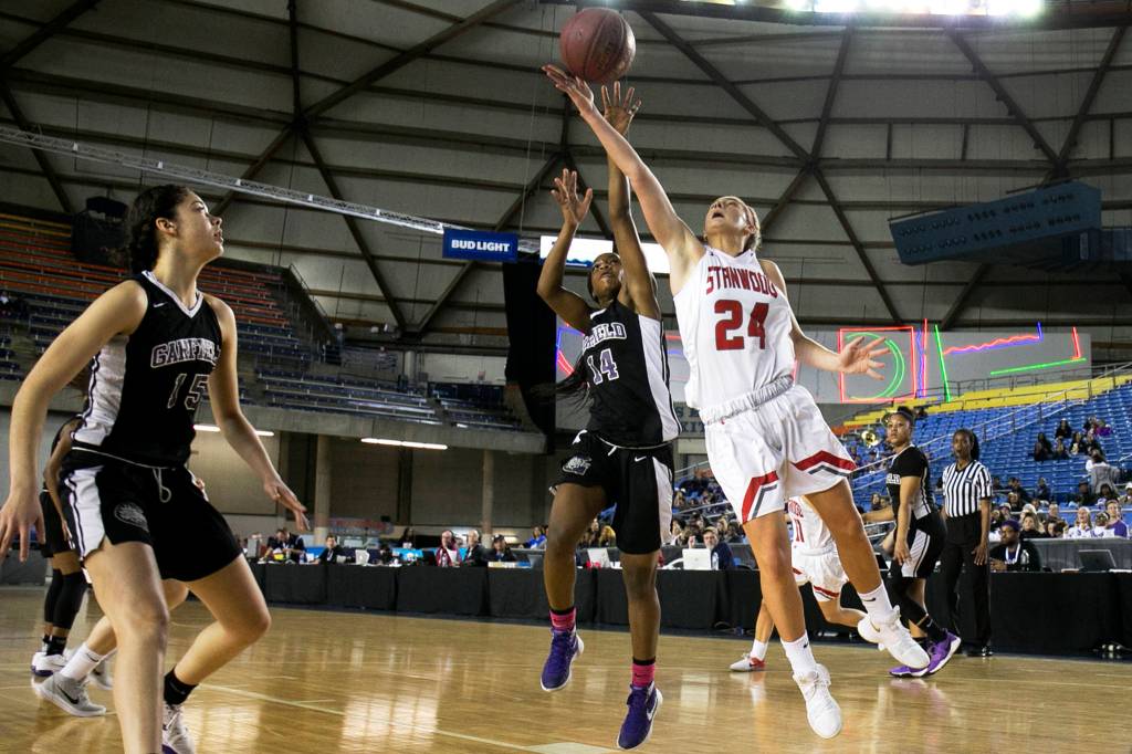 Stanwoods Jillian Heichel attempts a shot with Garfields Emani Turner defending and Garfields Dalayah Daniels (far left) looking on during the semifinals of the 3A Hardwood Classic at the Tacoma Dome on March 2. (Kevin Clark / The Herald)