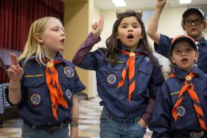 Cub Scout Grace Davis (left) recites the Scout Oath with other members of Packs 121 and 16 at Silver Lake Elementary on Monday in Everett. Davis, 7, made history as the first registered girl Cub Scout in the Mount Baker Council. (Andy Bronson / The Herald)