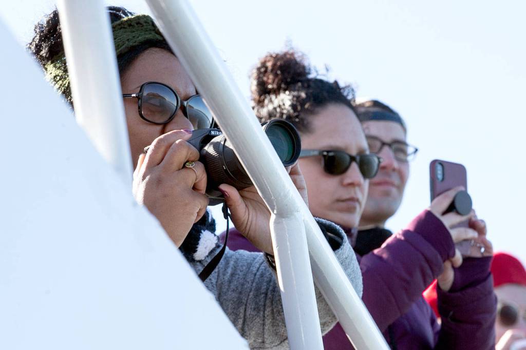 Cameras at the ready, whale watchers aboard the Island Explorer 3, which sails out of Everett, await breaches by gray whales. (Kevin Clark / The Daily Herald)