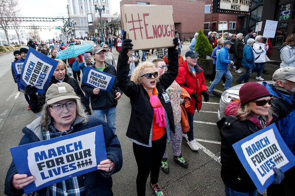 Linda Carbajal (center) marches down Hewitt Avenue in Everett with thousands of other protesters during a March for Our Lives rally downtown on Saturday. (Ian Terry / The Herald)