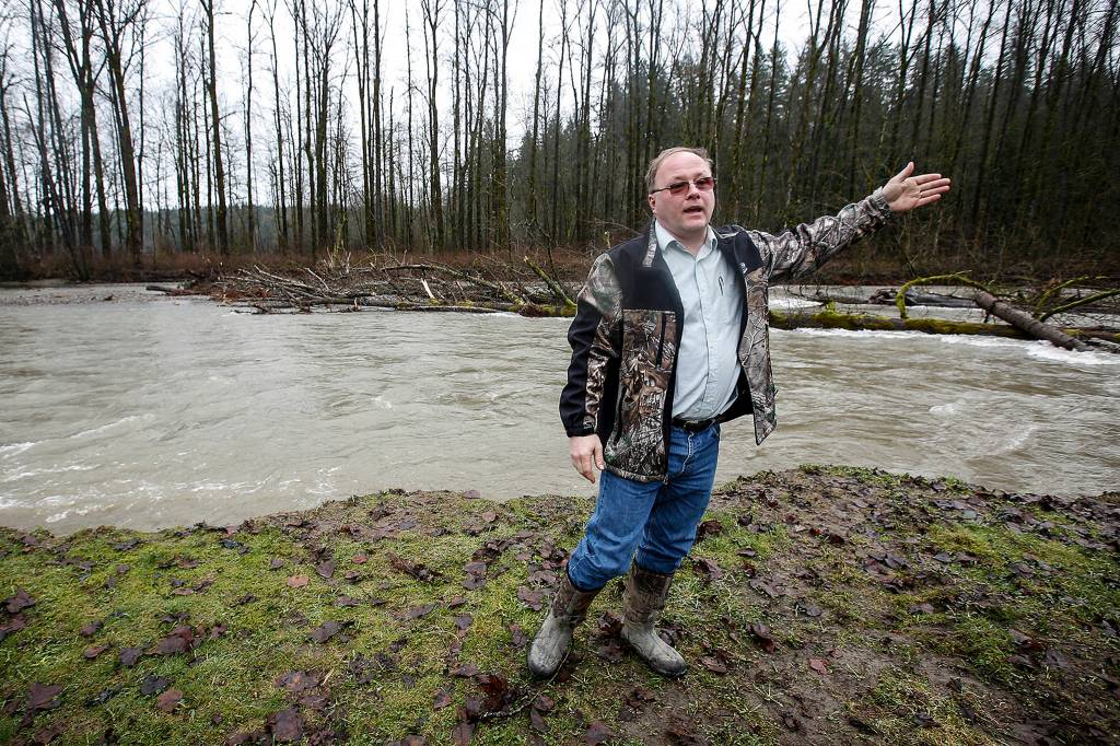 Marek Novy stands on his property, between Lake Stevens and Granite Falls, on Feb. 6. The Pilchuck River is eating away at Novys land which used to extend to where downed trees in the river can be seen now. (Ian Terry / The Herald)