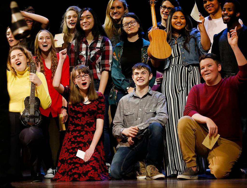 Marysville Pilchuck junior Laura Davis, in the flowered dress, joins other high school students from the region on the Paramount stage at the conclusion of student performances Wednesday. (Dan Bates / The Herald)