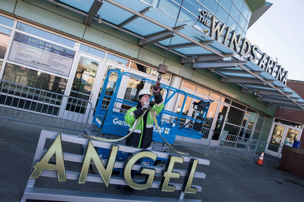 Sign installer Ted Merritt, from Barry Sign Systems, hooks up the final word for the new Angel of the Winds Arena sign at the corner of Hewitt Ave and Oakes Ave. on March 16 in Everett. (Andy Bronson / The Herald)