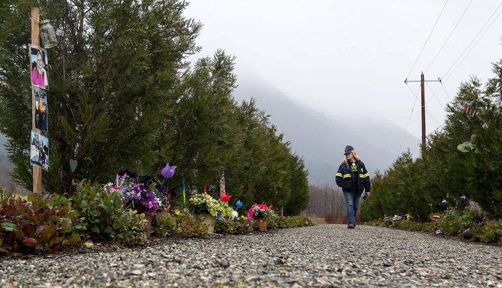 Darrington firefighter Pam Fritchman on Thursday walks among cedar trees planted to honor victims of the 2014 Oso mudslide on the four-year anniversary of the tragedy. (Ian Terry / The Herald)