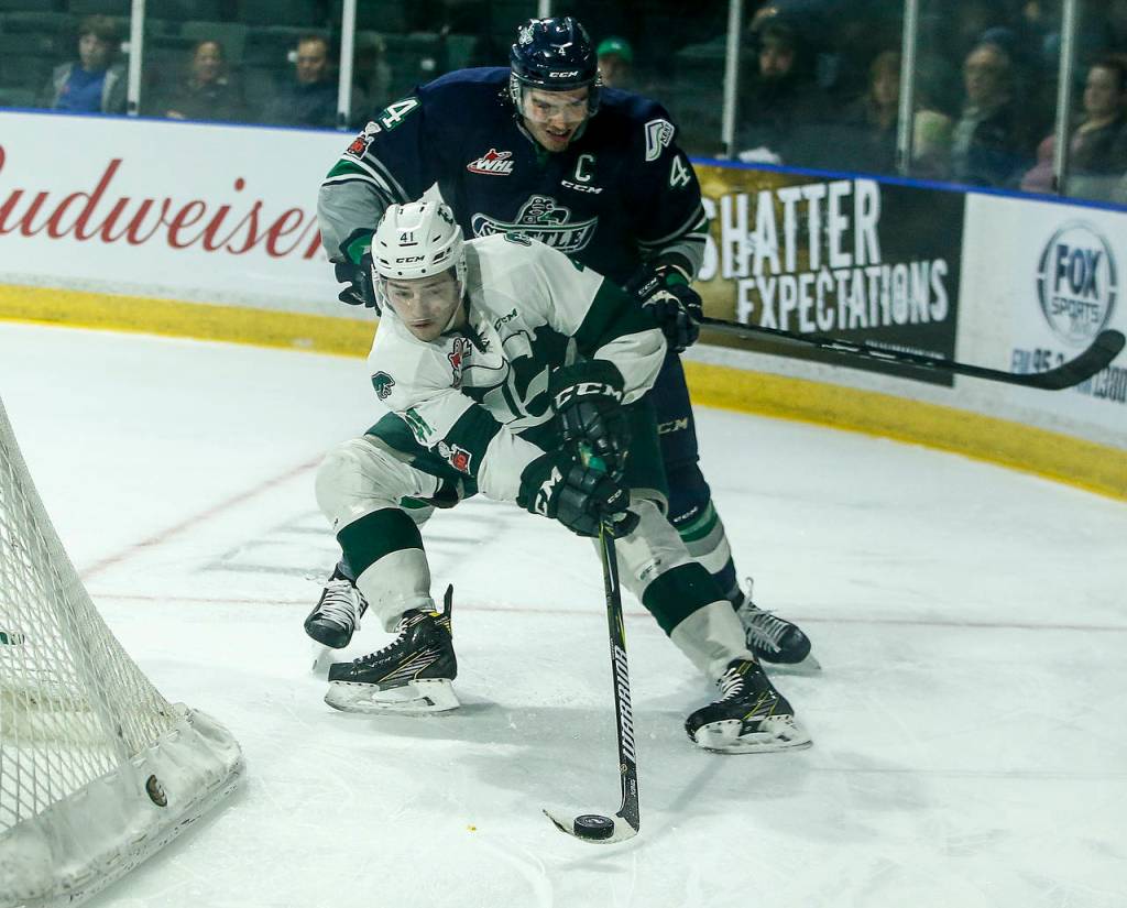 Silvertips forward Garret Pilon (41) keeps control of the puck as the Thunderbirds Turner Ottenbreit defends during the first game of an opening-round playoff series on March 23, 2018, at Angel of the Winds Arena in Everett. (Ian Terry / The Herald)