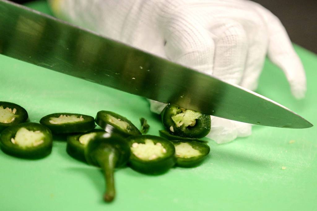 A contestant chops a jalapeno pepper. Ten young chefs competed in the contest. (Kevin Clark / The Herald)