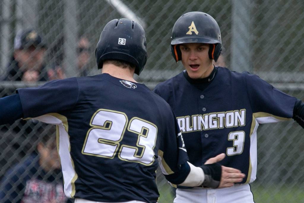 Edmonds-Woodways Jack Seward (left) celebrates a run with teammate Trevor Kazen on Wednesday at Arlington High School. (Kevin Clark / The Daily Herald)