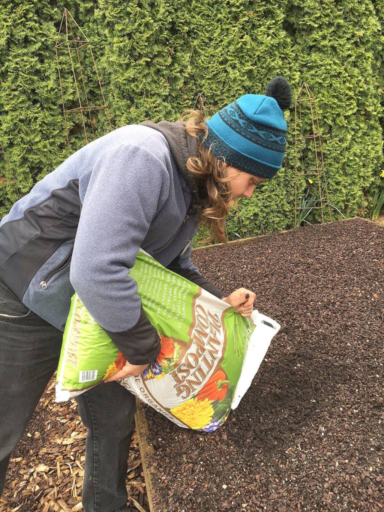 Hawkins adds organic compost to a vegetable garden. Smith says an inch or two is plenty to work into the soil for growing vegetables, flowers or for established shrubs and trees. (Photo by Nicole Phillips)