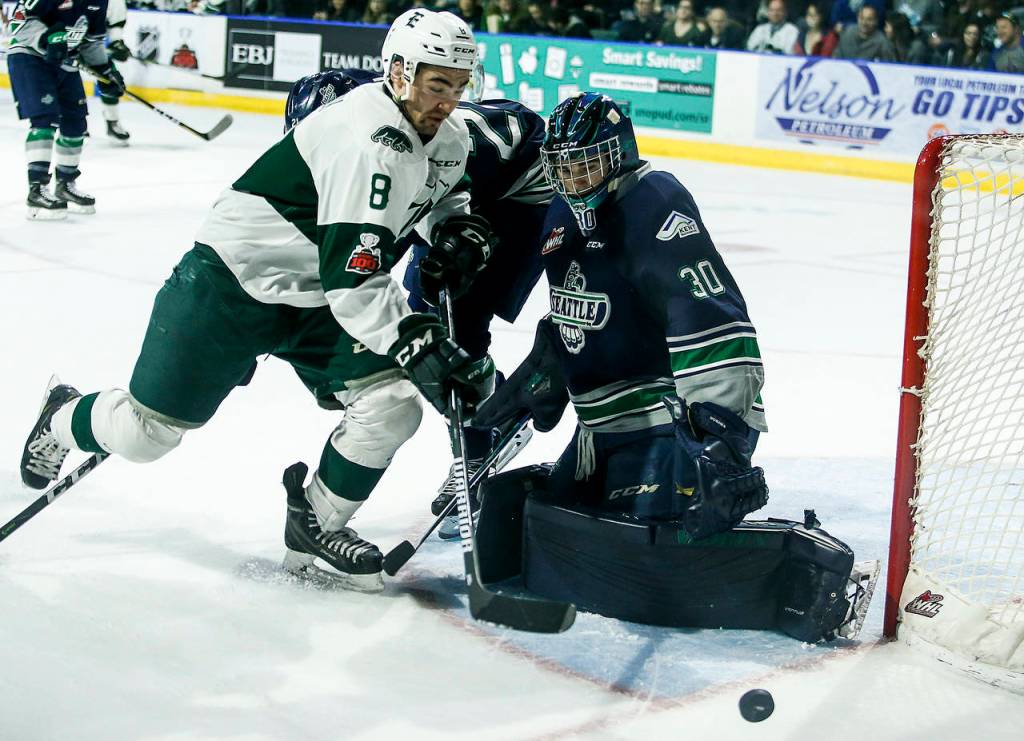Silvertips right wing Patrick Bajkov (8) battles in front of the net as Seattle goaltender Liam Hughes (30) looks for the puck during a playoff game at Angel of the Winds Arena in Everett on Saturday, March 31. (Ian Terry / The Herald)