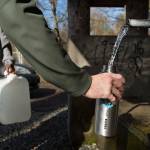 Paul Jung fills one of two water bottles at the artesian well on 164th Street on Monday, April 2, 2018 in Lynnwood, Wa. Jung who lives in Oak Harbor, says he always stops by if he is in the area. (Andy Bronson / The Herald)