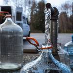 People fill up various water jug and containers at the artesian well on 164th Street on Monday, April 2, 2018 in Lynnwood, Wa. (Andy Bronson / The Herald)