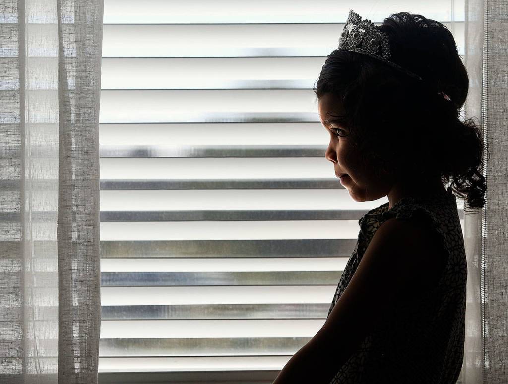 A springlike day finds 4-year-old Aria Hansens silhouette in a window, and its wearing a tiara. (Dan Bates / The Herald)