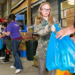 Taylor Webster hands off a bag of food at the Sultan Food Bank on Saturday. (Kevin Clark / The Herald)