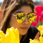 The tulips fields at Tulip Town are reflected in the mirrored sunglasses worn by Silvia Iraheta, of Bellingham, on Thursday, May 4, 2017 in Mount Vernon, Wa. The Skagit Valleys tulip festival ends Sunday. (Andy Bronson / The Herald)