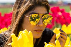 The tulips fields at Tulip Town are reflected in the mirrored sunglasses worn by Silvia Iraheta, of Bellingham, on Thursday, May 4, 2017 in Mount Vernon, Wa. The Skagit Valleys tulip festival ends Sunday. (Andy Bronson / The Herald)
