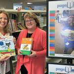 Cheri Ryan of the Elizabeth Ruth Wallace Living Trust congratulates Susan Dibble of Page Ahead with a grant that will allow the nonprofit to provide books and reading programs to Edmonds School District students. (Contributed photo)