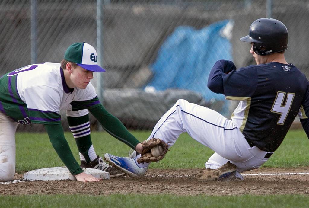 Edmonds-Woodways Gunnar Whitelaw tags out Arlingtons Dylan Corporon at Arlington High School on March 28, 2018. Arlington won 6-5. (Kevin Clark / The Herald)