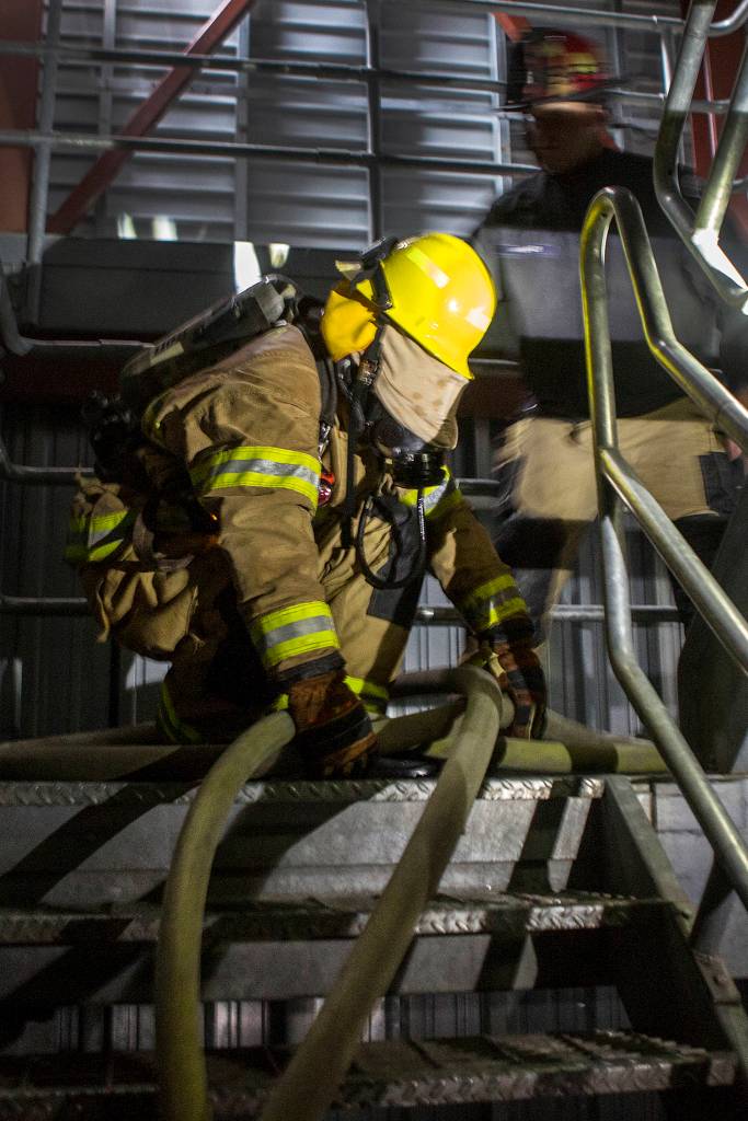 Snohomish County Fire district 7 recruit Johnson Brooks tries to follow the correct fire hose up a stairwell during the first fire training academy at the South Snohomish Fire & Rescue training ground on March 26 in Everett. (Andy Bronson / The Herald)