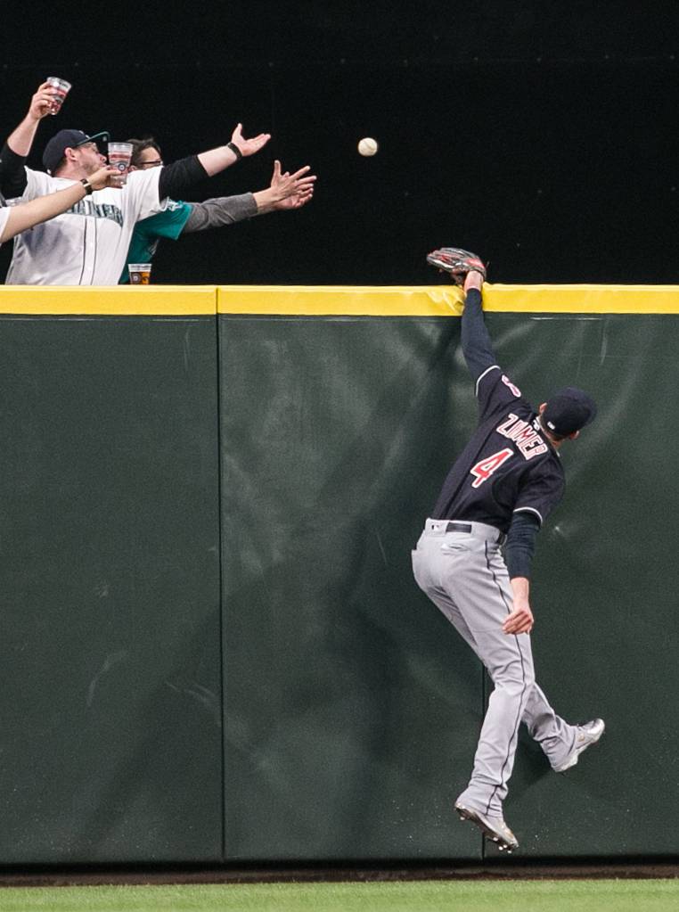 The Indians Bradley Zimmer attempts a grab, resulting in a two-run homer by Mariners Nelson Cruz in the first inning of the <a href="http://www.heraldnet.com/sports/hernandez-cruz-lead-mariners-over-indians-in-season-opener/" target="_blank">home opener</a> at Safeco Field in Seattle on March 29. (Kevin Clark / The Herald)