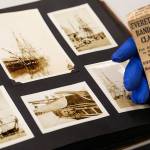 Although engrossed in pictures of Old Ironsides, William Vincent pauses to read a vintage newspaper clipping handed to him by Jerry Solie. It is about the Everett Elks Band winning an award. (Dan Bates / The Herald)