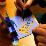 Brayden Whetstine, 12, from Haller Middle School, applies finishing touches to the pop-up card he created with his message. (Dan Bates / The Herald)
