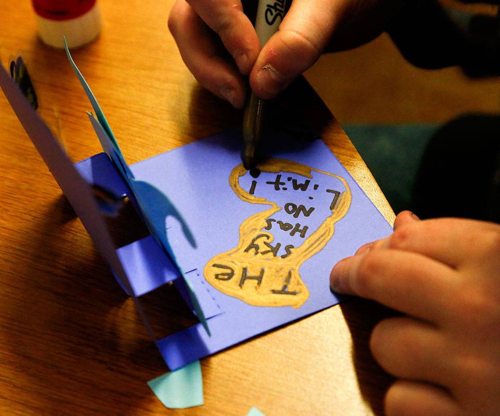 Brayden Whetstine, 12, from Haller Middle School, applies finishing touches to the pop-up card he created with his message. (Dan Bates / The Herald)