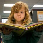 Paisley Molnick, 5, reads a book during the grand opening of the new Sno-Isle Libraries branch at Lakewood/Smokey Point in January. Sno-Isle Libraries is seeking voter approval of a levy increase in the April 24 special election. (Kevin Clark/The Daily Herald)